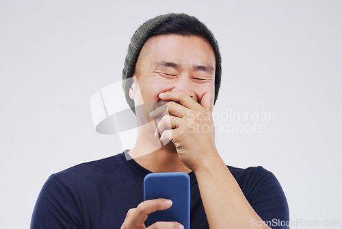 Image of Smile, funny and Asian man with a smartphone, connection or happiness against grey studio background. Male person, happy or guy with a cellphone, mobile app and meme with social media, humor or comic