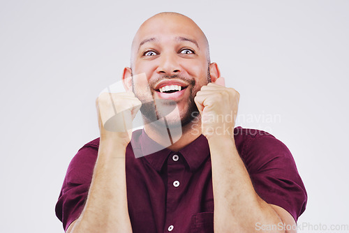 Image of Celebration, excited and portrait of a man in a studio with a surprise, wow or omg facial expression. Happy, smile and face of male model with fist pump to celebrate an achievement by gray background