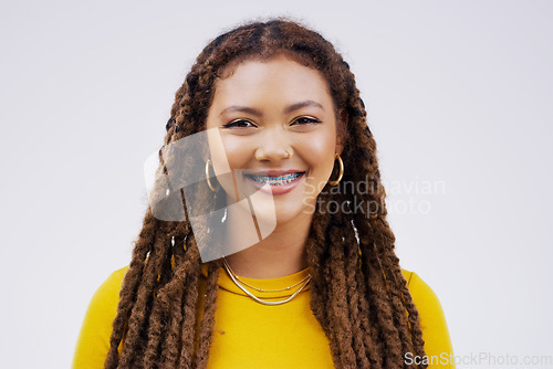 Image of Happy, smile and portrait of a woman with braces isolated on a white background in a studio. Happiness, confident and a face headshot of a young girl with dreadlocks, confidence and positivity