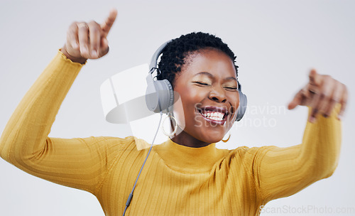 Image of Dance, happy and a black woman with music on headphones isolated on a white background in studio. Smile, crazy and an African girl listening to audio, dancing and streaming radio for happiness