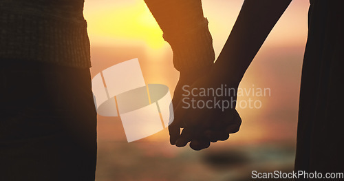 Image of Holding hands, couple and sunset sky at beach with love on vacation, holiday or adventure. Man and woman silhouette outdoor to celebrate marriage, commitment and ocean travel or date in nature