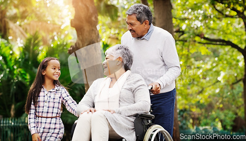 Image of Grandparents, park and a senior woman in a wheelchair together with her husband and granddaughter. Disability, family or kids and a girl child bonding with her senior relatives in a natural garden