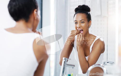 Image of Woman flossing teeth in bathroom, mirror and oral hygiene, morning routine with product for dental health. Female person at home with grooming and self care, clean mouth with floss and wellness