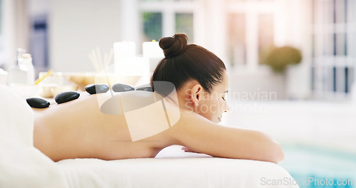 Image of Woman, relax and rock massage at spa for zen, physical therapy or treatment at the resort. Happy female person relaxing with hot stone back for muscle relief, tension or peaceful wellness at a salon