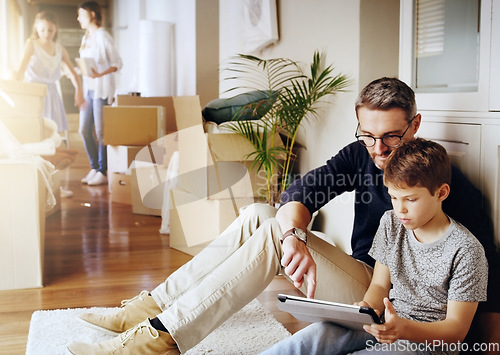 Image of Man, boy and tablet, playing games and relax, break from unpacking and moving into new house. Father, son and wireless tech with property, real estate and rest with video game online and bonding