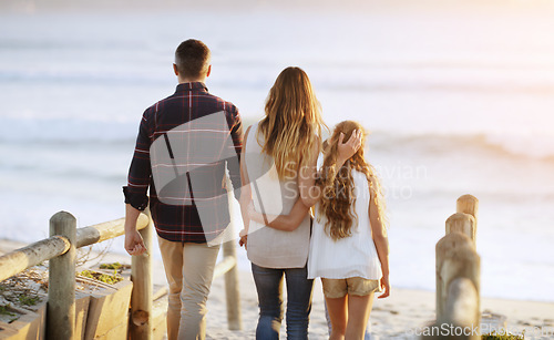 Image of Family, back and walking together at beach with love, care and bonding on vacation with sunset, waves and kid. Father, mother and daughter with embrace, walk and ocean with dusk sunshine on holiday