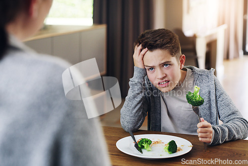Image of Disgust, food and child with vegetables in home for nutrition, health and cooking. Lunch, angry and dinner with boy and refuse to eat broccoli at tablet for eating problem, frustrated and dislike