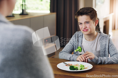 Image of Disgust, vegetable and fear with child and broccoli for nutrition, health and cooking. Sad, angry and dinner with boy and refuse to eat food at home for eating problem, frustrated and dislike