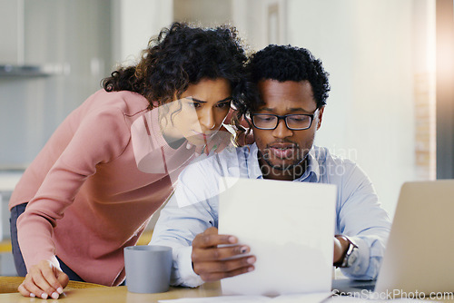 Image of Couple, document and finance in budget planning, bills or expenses together in the kitchen at home. Serious man and woman person working on paperwork in financial, mortgage or investment strategy