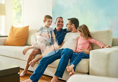 Image of Gay parents, family hug and living room couch with dads and kids together with laugh and tickle. Parent love, bonding and care with father, papa and children in a home with a smile and lgbt people