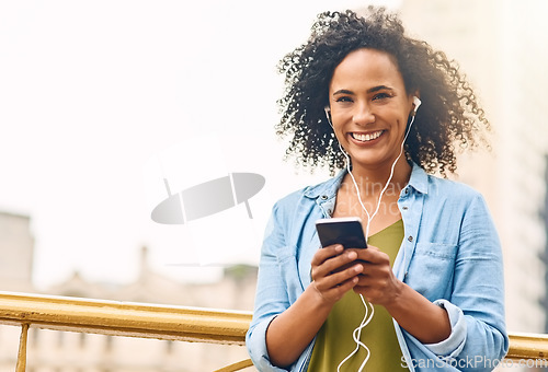 Image of Happy, music and portrait of woman in city with phone listening to track, audio and mockup in urban town. Traveling, smile and beautiful African female person streaming radio for relaxing on weekend