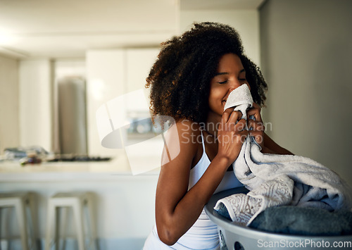 Image of Laundry smell, African woman and home cleaning chores with happiness and calm. Smile, fresh clothes and happy with housekeeping of a black female person in a house feeling relax in the morning