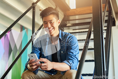 Image of Asian man, office stairs and texting with phone in portrait with chat, smile and social network app. Young japanese creative, web design startup and relax on steps in workplace, contact and cellphone