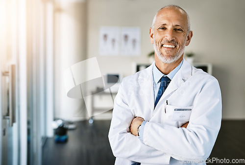 Image of Mature doctor, clinic and portrait with arms crossed in hospital feeling proud from medical work. Healthcare, wellness and professional employee with happiness from health support and physician job