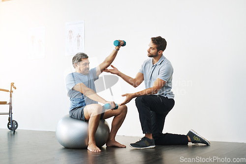 Image of Dumbbells, physiotherapy and exercise with doctor and old man for rehabilitation, training and balance. Health, pain and healing with senior patient and physiotherapist for consulting, muscle or help