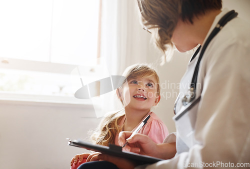 Image of Child doctor, girl and talking trust with medical checklist in a hospital for wellness and health. Happiness, clinic consultant and pediatrician with healthcare and appointment with a kid form