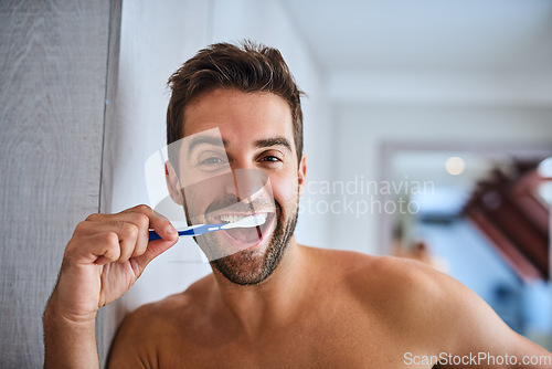 Image of Portrait, toothbrush and face of happy man brushing teeth in home for dental wellness, healthy habit and gums. Excited guy cleaning mouth for fresh breath, oral hygiene or morning routine in bathroom