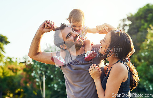 Image of Family, dad and daughter on shoulders in park with mom, happiness or love in summer sunshine. Young couple, baby girl or laugh together for freedom, bond or holding hands for care, backyard or garden