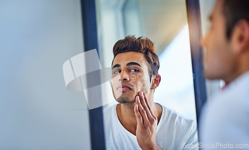 Image of Skincare, man looking in a mirror and face in bathroom with lens flare. Body treatment or cosmetics for wellness, dermatology or skin routine and facial care with male person at home in morning