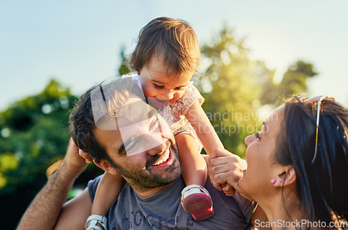 Image of Family, father and daughter on shoulders in park with happy mom, love and summer sunshine. Young couple, baby girl or laugh together for freedom, bond and helping hand for care, backyard or garden