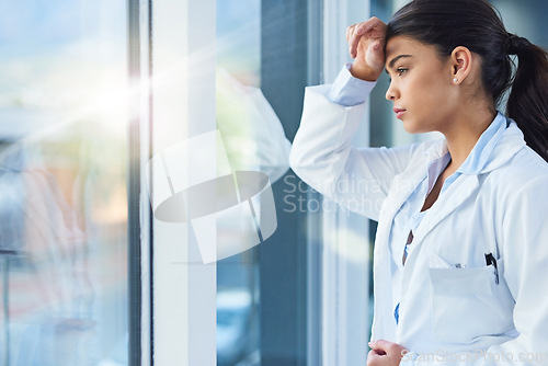 Image of Stress, thinking and doctor woman by window with worry, anxiety and tired with headache in clinic. Healthcare, mental health and sad female health worker stressed, depressed and burnout in hospital