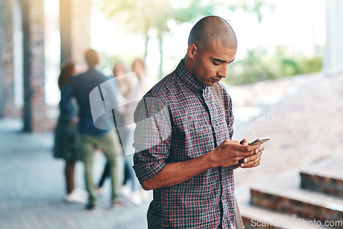 Image of Young man, student and texting with smartphone on campus, university and reading on social media app. Guy, cellphone and web search outdoor with connectivity, blog and email communication on internet