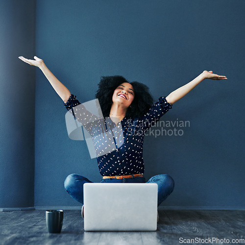 Image of Laptop, achievement and woman in celebration on the floor by a blue wall for good news or success. Happy, smile and excited professional female employee with job promotion to celebrate with computer.