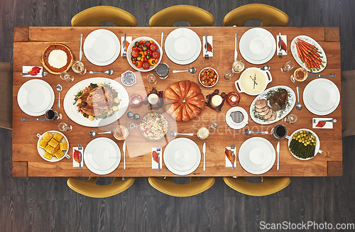 Image of Dinner, event and top view of Christmas lunch with food on a table from above of a home dining room for celebration. Chicken, party and holiday or vacation vegetables, meat and salad for a birthday