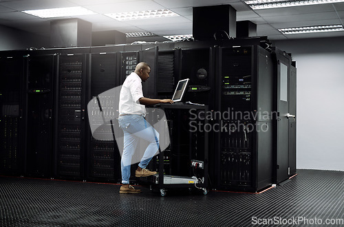 Image of IT support, black man or coding on computer in server room for big data, network glitch or digital website. Code, fixing or technician typing on laptop testing UX, programming or software development