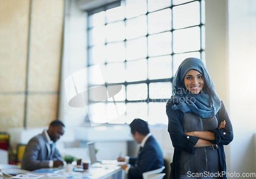 Image of Muslim, business woman and portrait in office with a smile, hijab and arms crossed for career pride. Arab female entrepreneur or leader at a corporate workplace with a positive mindset and motivation