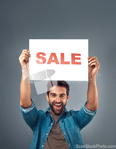 Image of Happy man, hands and sale sign for advertising, branding or marketing against a grey studio background. Excited male person, surprise holding poster with smile for sales, discount or advertisement