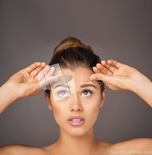 Image of Stress, touching and a woman with face wrinkles isolated on a dark background in a studio. Concern, anxiety and a young girl frustrated with skincare, filler and a facial beauty cosmetics mistake