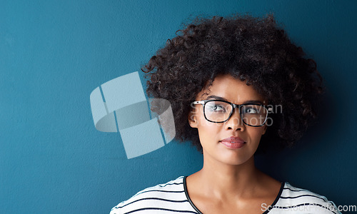Image of Optometry, thinking and woman with spectacles in a studio with daydreaming, pensive or idea face expression. Optical, vision and African female model with glasses by blue background with mockup.