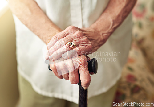 Image of Hands, walking stick and closeup with senior woman, injury and disabled with balance in retirement in house. Cane, elderly lady and person with disability, support or recovery in home with lens flare