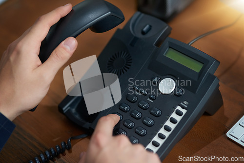 Image of Hand dial, voip telephone and office for communication, contact us and consulting agent. Telemarketing person, phone call or button on table for customer service, help or tech support on network