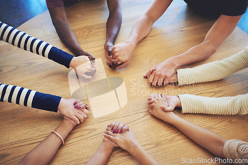 Image of Circle, group and holding hands with people, pray and support for faith, trust or solidarity on desk. Teamwork, helping hand and together with praying, religion or gratitude with mindfulness on table