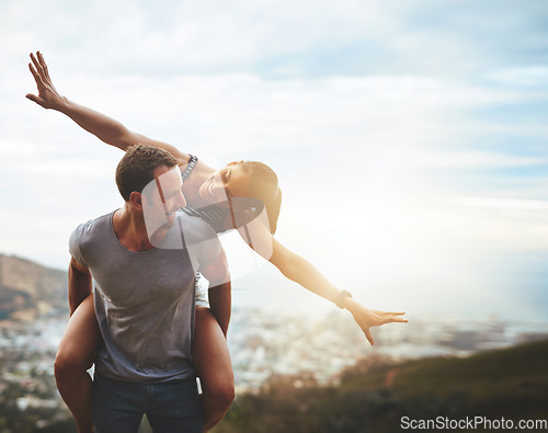 Image of Travel, happy couple with piggyback ride and mountain outdoors with lens flare. Sunshine or mockup space, nature adventure or freedom and people playing on holiday break or summer vacation together.