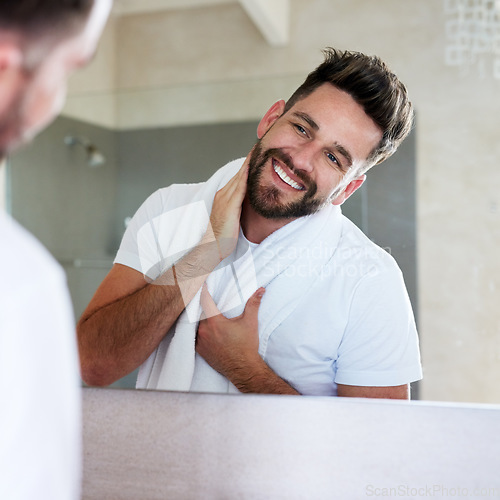 Image of Grooming, morning and man with cleaning and mirror routine in a bathroom with a smile. Home, reflection and skincare with a young male person feeling happy from beard growth and face dermatology