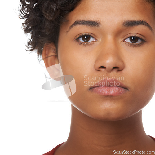 Image of Young woman, face focus and serious in a studio of a female teenager with white background. Beautiful, Indian teen person and youth portrait feeling focused and concentrating with a girl alone