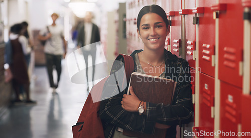Image of Portrait, education and books with a student girl by her locker in the hallway of her school. Learning, university and scholarship with a college pupil holding a notebook for studying knowledge