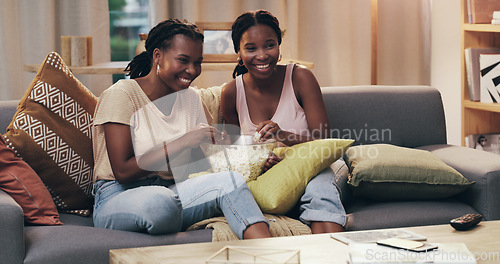 Image of Movie night, happy and women with popcorn on the sofa for a television show, film or comedy. Smile, relax and African friends on the couch eating food and streaming a subscription service on tv