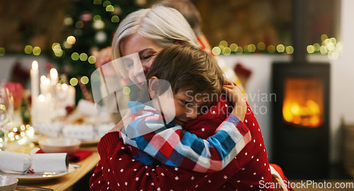 Image of Christmas, love and a grandma hugging her grandchild in the home during the festive season together. Family, children or holiday with a young boy and senior woman in a house to hug while bonding