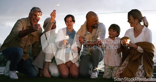 Image of Outdoor, happy and family with fireworks, celebration and party with fun, backyard and cheerful together. Grandparents, mother and father with children, kids and happiness with sparklers and love