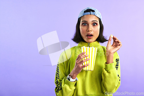 Image of Shocked, wow and woman with popcorn for a movie or streaming service or cinema and in studio against a purple background. Video, entertainment and film or television or omg and box snack on mock up