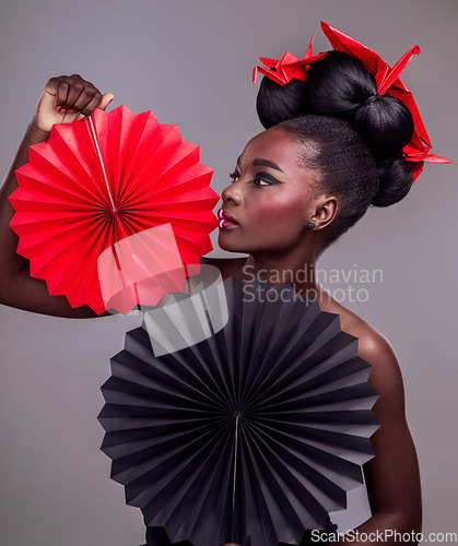 Image of Art, makeup and creative with black woman in studio for origami, beauty and culture. Traditional, cosmetics and paper design with female model and fans on grey background for fashion, retro or color