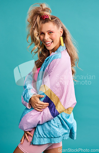 Image of 80s fashion, retro style and woman portrait with vintage, neon and happiness in a studio. Blue background, female person and jacket of a model with workout, fitness and training outfit with a smile