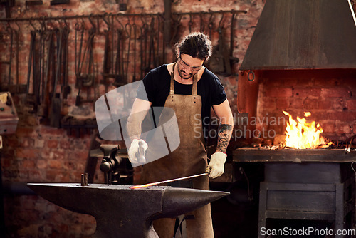 Image of Worker, blacksmith and metal forge in workshop and manual working on hot steel with hammer, fire and sparks. Man, welding job or iron tools manufacturing and expert, trade and dark workspace