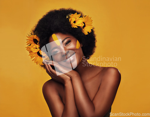 Image of Natural, hair and sunflower with portrait of black woman in studio for beauty, creative or spring. Makeup, cosmetic and floral with face of model on yellow background for art, self love or confidence