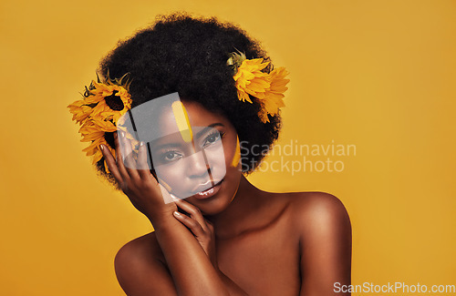 Image of Natural, sunflower and hair with portrait of black woman in studio for beauty, creative or spring. Makeup, cosmetics and floral with face of model on yellow background for art, self love or glow