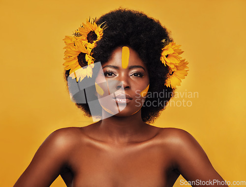 Image of Makeup, sunflower and glow with portrait of black woman in studio for beauty, hair or spring. Natural, cosmetic and floral with face of model on yellow background for art, self love or confidence